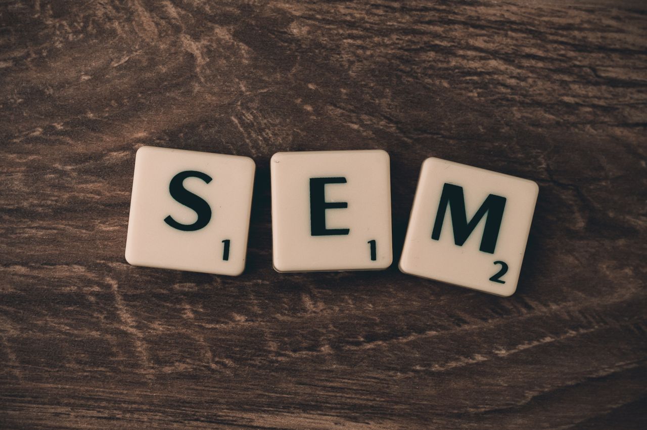 Services-02 Wooden background with letter tiles spelling SEM, representing search engine marketing.